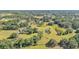 Expansive aerial shot of a lush property with mature trees, a serene pond, and a rustic barn at 4910 Thonotosassa Rd, Plant City, FL 33565