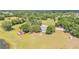 Aerial view of a home with a large lot with surrounding lush greenery and a barn at 4910 Thonotosassa Rd, Plant City, FL 33565