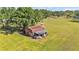 Overhead shot of a quaint red barn, highlighting the rural charm of the property and its expansive green space at 4910 Thonotosassa Rd, Plant City, FL 33565