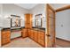 Spacious bathroom featuring dual vanities with granite countertops and oak cabinetry, adjacent to a glass paneled door at 4910 Thonotosassa Rd, Plant City, FL 33565