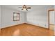 A bedroom featuring a ceiling fan, hardwood floors, a window with wooden shutters, and white walls at 4910 Thonotosassa Rd, Plant City, FL 33565