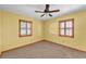 Sunny bedroom features a ceiling fan, carpeted floors, and two windows with wooden shutters at 4910 Thonotosassa Rd, Plant City, FL 33565