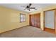 Bedroom featuring a ceiling fan, carpet, a window with wooden shutters, and a closet with paneled doors at 4910 Thonotosassa Rd, Plant City, FL 33565