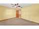 Spacious bedroom features a ceiling fan and carpet floors at 4910 Thonotosassa Rd, Plant City, FL 33565