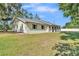 Charming home with a painted brick exterior, complimented by large windows and professionally landscaped grounds at 4910 Thonotosassa Rd, Plant City, FL 33565