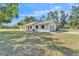 Charming single-story white brick home with a well-manicured lawn and an attached garage at 4910 Thonotosassa Rd, Plant City, FL 33565