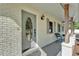 Inviting front porch featuring a decorative door, gray painted brick, outdoor lighting, and seating with decorative shutters at 4910 Thonotosassa Rd, Plant City, FL 33565