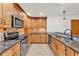 Updated kitchen features granite countertops, wood cabinets, and stainless steel appliances at 4910 Thonotosassa Rd, Plant City, FL 33565