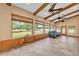 Spacious living room features vaulted ceilings, wood beams, and view of large backyard at 4910 Thonotosassa Rd, Plant City, FL 33565