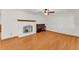 Spacious living room featuring hardwood floors, a white brick fireplace, a piano, and an open layout for flexible furnishing at 4910 Thonotosassa Rd, Plant City, FL 33565