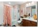 Comfortable bathroom features a shower-tub, vanity and decorative pink shower curtain at 2125 Wild Grape Pl, Riverview, FL 33578