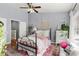 Charming bedroom with a black iron bed, decorative rug, ample natural light, and soothing color palette at 2125 Wild Grape Pl, Riverview, FL 33578