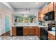 Open kitchen with wood cabinetry, black appliances, subway tile backsplash, and a pass-through to the living area at 2125 Wild Grape Pl, Riverview, FL 33578