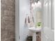 Stylish powder room with pedestal sink, decorative wallpaper, modern lighting, and unique textures at 2125 Wild Grape Pl, Riverview, FL 33578