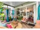 Cozy sunroom featuring woven furniture, plants, and view to the living area at 2125 Wild Grape Pl, Riverview, FL 33578