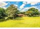 Aerial view of home on expansive lot with lush lawn, mature trees, and a picturesque pond creating a private oasis at 4101 N Forbes Rd, Plant City, FL 33565