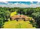 Aerial view of home featuring mature trees, a screened patio, and a lush lawn in a secluded oasis at 4101 N Forbes Rd, Plant City, FL 33565