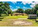 Large backyard featuring lush greenery, mature trees, a storage shed, and plenty of space for outdoor activities at 4101 N Forbes Rd, Plant City, FL 33565