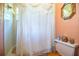 The bathroom features a toilet and a shower adorned with a decorative lace curtain at 4101 N Forbes Rd, Plant City, FL 33565