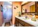 Bathroom with a marble countertop vanity, wood cabinets, and a bathtub with shower at 4101 N Forbes Rd, Plant City, FL 33565