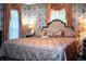 This bedroom is decorated with floral wallpaper, a large bed, and peach-colored window treatments at 4101 N Forbes Rd, Plant City, FL 33565