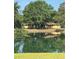 A serene view of the home reflected in a pond, surrounded by lush greenery and mature trees at 4101 N Forbes Rd, Plant City, FL 33565