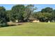 Ranch-style home nestled amongst mature trees, with a pond in the front yard at 4101 N Forbes Rd, Plant City, FL 33565