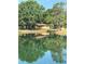Beautiful view of the home reflected on a pond with ducks swimming nearby, surrounded by lush trees at 4101 N Forbes Rd, Plant City, FL 33565