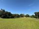 Expansive green lawn and lush trees surround a tranquil pond on this property at 4101 N Forbes Rd, Plant City, FL 33565