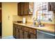 Functional kitchen with wood cabinets, stainless steel sink, and a bright yellow wall at 4101 N Forbes Rd, Plant City, FL 33565