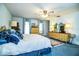 Spacious main bedroom with a ceiling fan, wooden furniture, blue carpet, and natural light at 4101 N Forbes Rd, Plant City, FL 33565