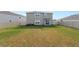 Fenced backyard area with immature trees and grass and a sliding glass door at 8009 Sail Clover Ln, Zephyrhills, FL 33540