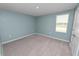 Cozy bedroom with blue walls, carpet flooring, and a window at 8009 Sail Clover Ln, Zephyrhills, FL 33540