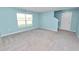 Carpeted bedroom featuring a bright window and adjacent staircase at 8009 Sail Clover Ln, Zephyrhills, FL 33540