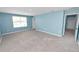 Bright bonus room featuring blue walls, carpet flooring, and a window offering ample natural light at 8009 Sail Clover Ln, Zephyrhills, FL 33540