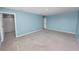 Open bonus room featuring blue walls, carpet flooring, and doors to other rooms at 8009 Sail Clover Ln, Zephyrhills, FL 33540