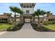 Community entrance with a stone archway and inviting walkway lined with palm trees at 8009 Sail Clover Ln, Zephyrhills, FL 33540