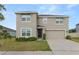 Front of home, featuring well-maintained landscaping and two-car garage at 8009 Sail Clover Ln, Zephyrhills, FL 33540