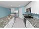 Open kitchen featuring an island, white cabinets, granite countertops, and stainless appliances at 8009 Sail Clover Ln, Zephyrhills, FL 33540