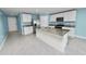 Bright kitchen featuring an island, white cabinets, stainless steel appliances, and granite countertops at 8009 Sail Clover Ln, Zephyrhills, FL 33540