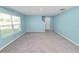 Bright, carpeted living room features a large window and neutral walls at 8009 Sail Clover Ln, Zephyrhills, FL 33540