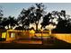 Backyard featuring a deck, above ground pool with string lights, privacy fence, and mature trees at 1411 Fernwood Pl, Seffner, FL 33584