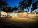 Charming home featuring a backyard with wooden deck, screened patio, and above ground pool with string lights at 1411 Fernwood Pl, Seffner, FL 33584