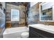 Beautiful bathroom featuring decorative tiles, a tub, and vanity, creating a relaxing and spa-like retreat at 1411 Fernwood Pl, Seffner, FL 33584