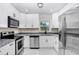 Modern kitchen with stainless steel appliances, granite countertops, and white cabinetry at 1411 Fernwood Pl, Seffner, FL 33584