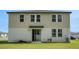 Large grassy backyard, complemented by the home's exterior with an access door and large windows on the second story at 203 Lovely Ct, Plant City, FL 33566