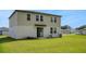 Large grassy backyard, complemented by the home's exterior with an access door and large windows on the second story at 203 Lovely Ct, Plant City, FL 33566