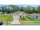 Two-story home with neutral siding, blue shutters, well-manicured lawn and landscaping creating a welcoming curb appeal at 203 Lovely Ct, Plant City, FL 33566