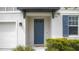 Inviting front entrance boasts a navy blue door, complemented by lush greenery and classic shutters at 203 Lovely Ct, Plant City, FL 33566