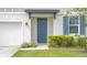 Inviting front entrance boasting a navy blue door, complemented by lush greenery and classic shutters at 203 Lovely Ct, Plant City, FL 33566